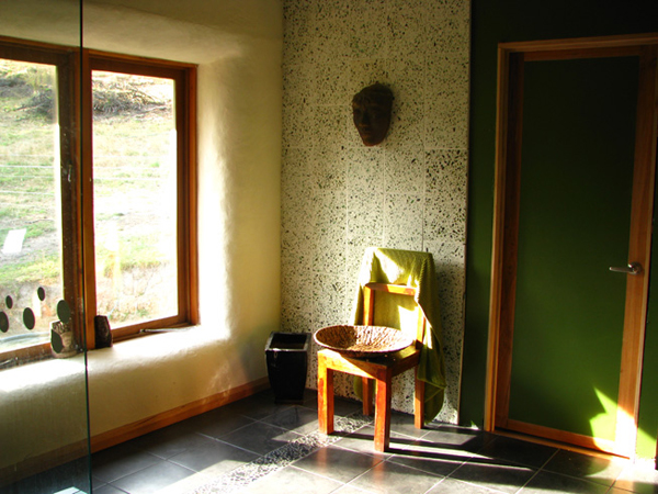 The bathroom, the wall tiles were handmade from smashed green wine bottles and a small amount of white cement